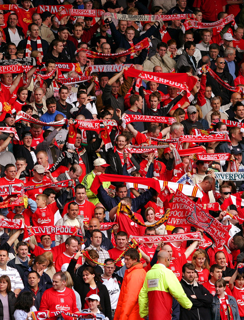 Fans of liverpool fc in football stadium in red jerseys