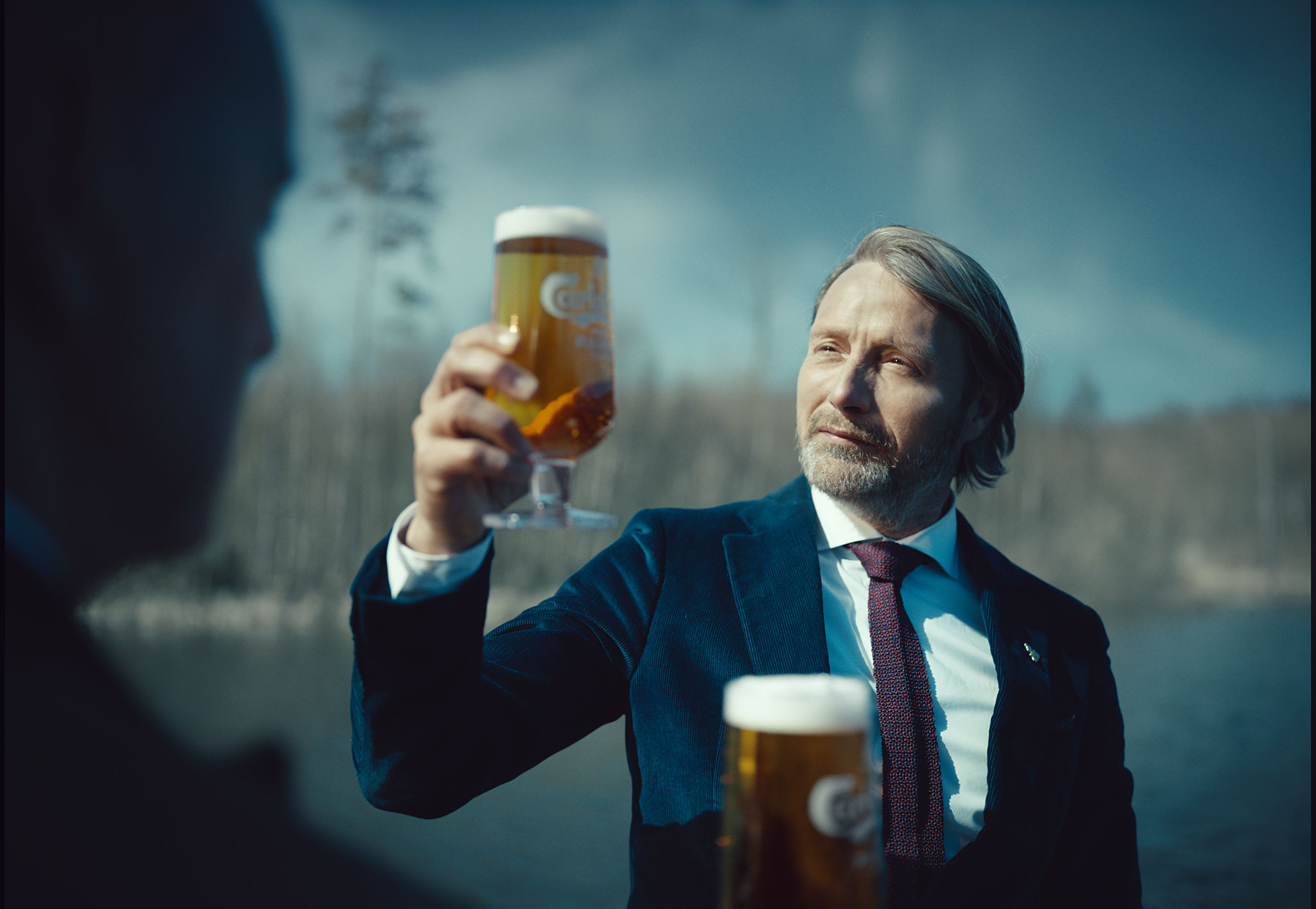 mads mikkelsen holding a new carlsberg rebrew in his hand